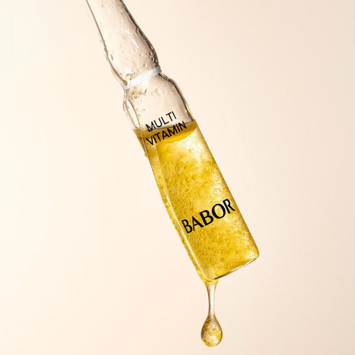 Babor Ampoule Multi Vitamin 14 ml ansigtsserum i en klar glasampul med en gylden dråbe og boblende gul væske.
