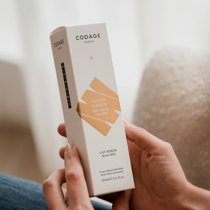 Codage Paris The Body Serum Milk 150 ml anti-age kropsserum i hvid emballage med guldgrafik holdt i hænderne