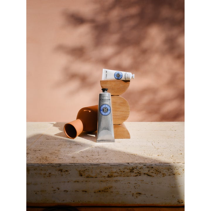 L'Occitane en Provence Shea Butter Hand Cream 30 ml fugtgivende håndcreme i sølv og hvid tube på dekorative træklodser.