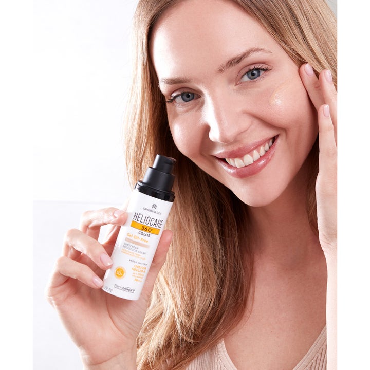 Heliocare 360 Color Gel Oil-Free SPF 50+ Beige 50 ml solbeskyttelse påføres af smilende kvinde på kinden
