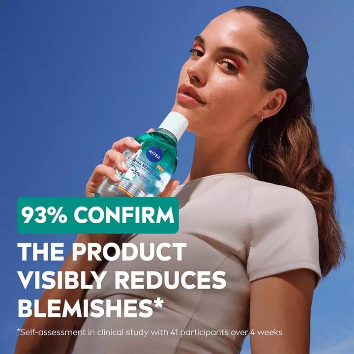 NIVEA Derma Skin Clear Micellar Water 400 ml ansigtsrens mod urenheder holdt af en kvinde mod en klar blå himmel