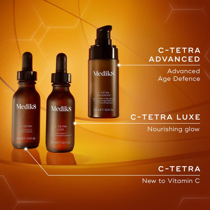 Medik8 C-Tetra Advanced 30 ml ansigtsserum med C-vitamin giver glød i brun pumpeflaske mod orange baggrund.