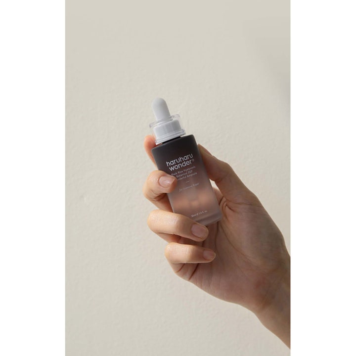 haruharu wonder Black Rice Hyaluronic 2GF Ampoule 30 ml fugtgivende serum i mørk glasflaske med hvid pipette i en hånd