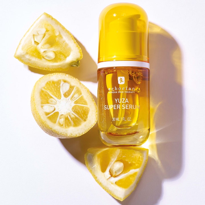 Erborian Yuza Super Serum 30 ml nærende ansigtsserum i gul glasflaske omgivet af friske yuzu-citrusfrugter.