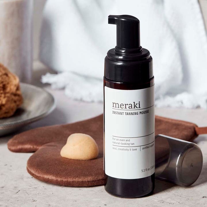 Meraki Instant Tanning Mousse 150 ml selvbruner giver naturlig glød vist med en klat skum på en brun handske