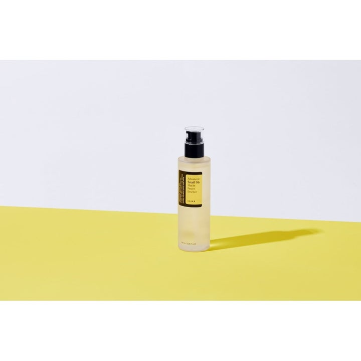 COSRX Advanced Snail 96 Essence Duo 200 ml fugtgivende hudpleje med snegleslim i klar pumpeflaske på gul baggrund