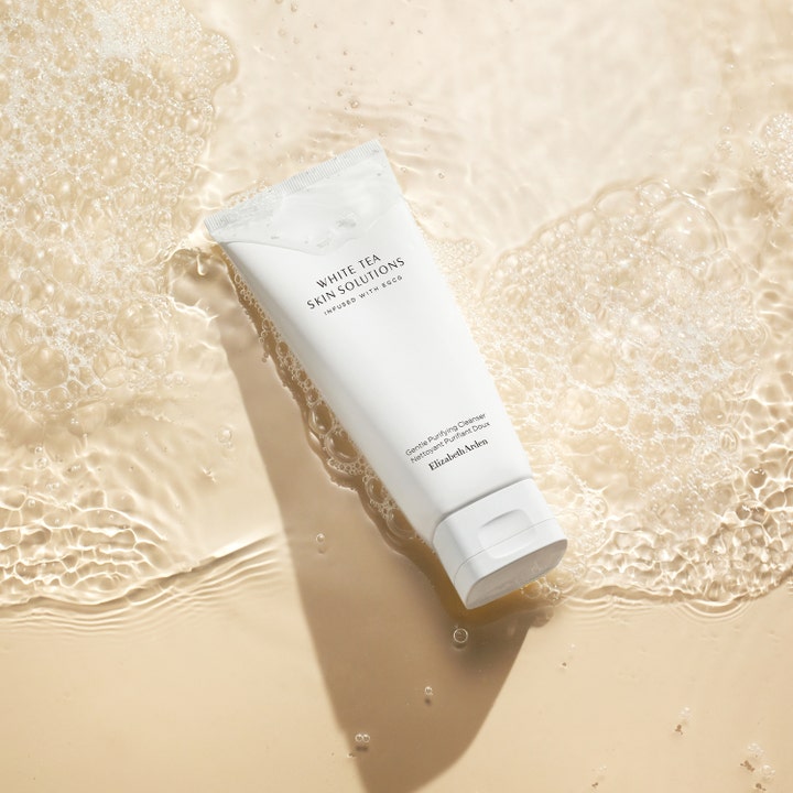 Elizabeth Arden White Tea Purifying Cleanser 125 ml i hvid tube omgivet af vand og rensende skum