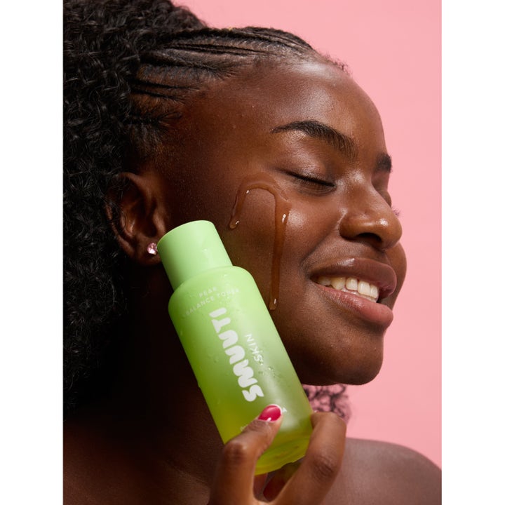 Smuuti Skin Pear Balance Toner 130 ml fugtgivende ansigtsvand i grøn flaske på smilende kvinde