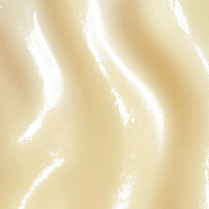 MANTLE The Daily Shield 50 ml solcreme til ansigtet har en cremet glansfuld tekstur i en lys beige nuance.