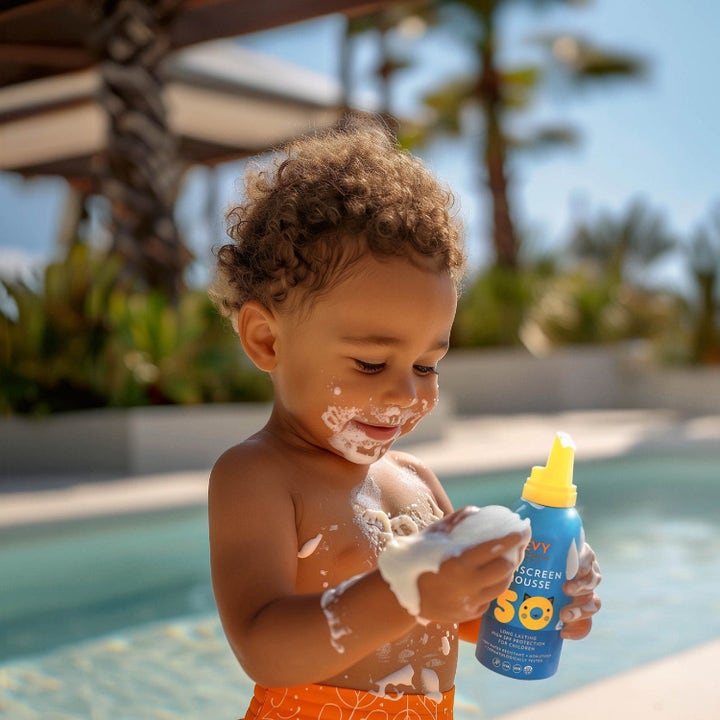 EVY Technology Sunscreen Mousse For Kids SPF50 beskyttende solcreme til børn ved en pool med hvid mousse på huden