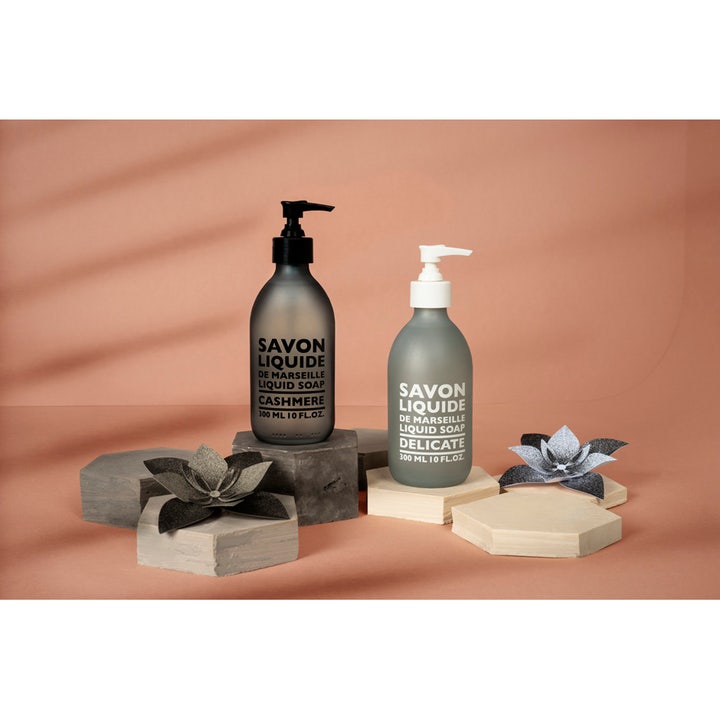 Compagnie de Provence Liquid Marseille Soap Cashmere 300 ml håndsæbe i mørk og lys frostet glas på dekorative blokke.