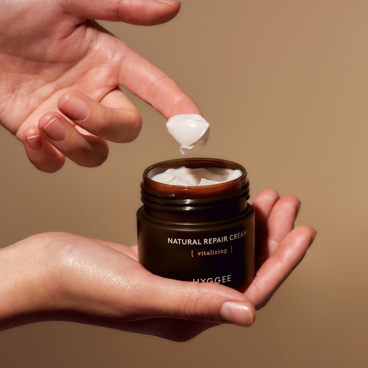 Hyggee Natural Repair Cream 50 ml ansigtscreme i mørk krukke med fyldig konsistens på en fingerspids
