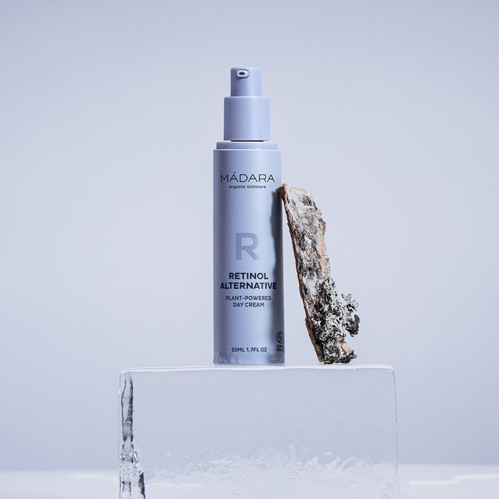 MÁDARA RETINOL ALTERNATIVE 50 ml plantebaseret dagcreme i lilla pumpeflaske på en isblok ved siden af bark.