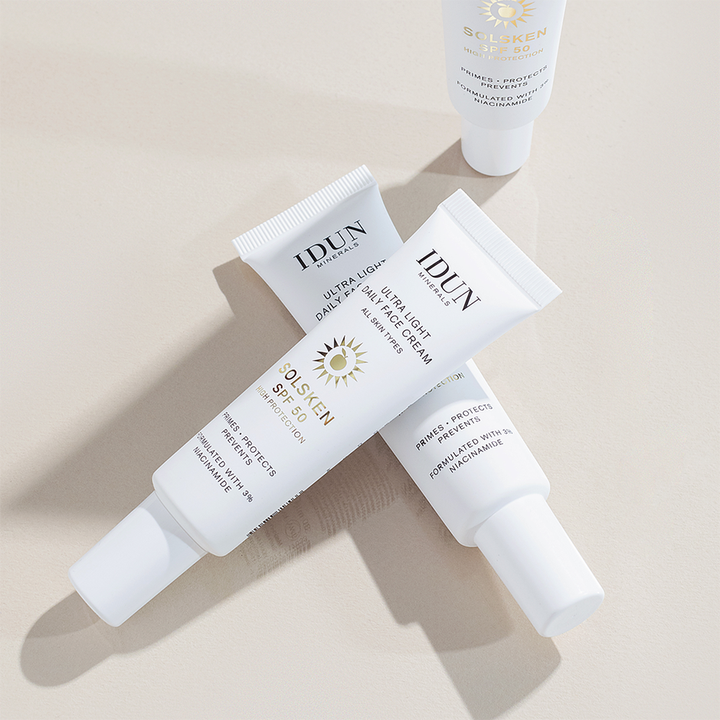 IDUN Minerals Ultra Light Daily Face Cream Solsken SPF50 30 ml solcreme med niacinamid i hvide tuber på lys baggrund