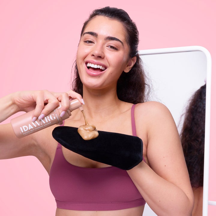 IDA WARG Cocoa Self-Tanning Mousse 150 ml påføres med sort handske og giver huden en solkysset glød