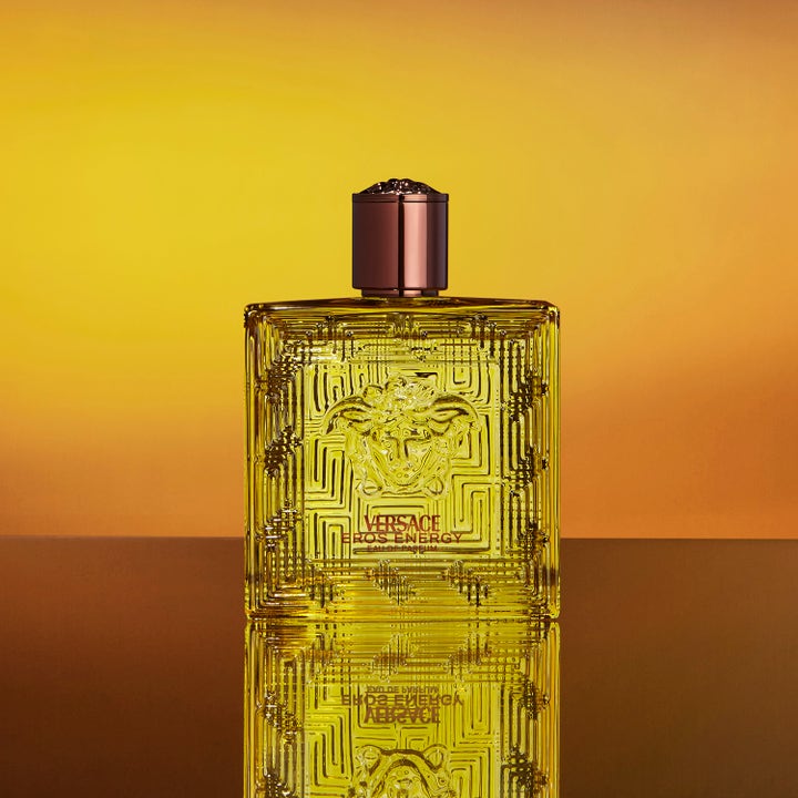 Versace Eros Energy 250 ml showergel giver energi i gul flakon med Medusa-motiv på varm baggrund.
