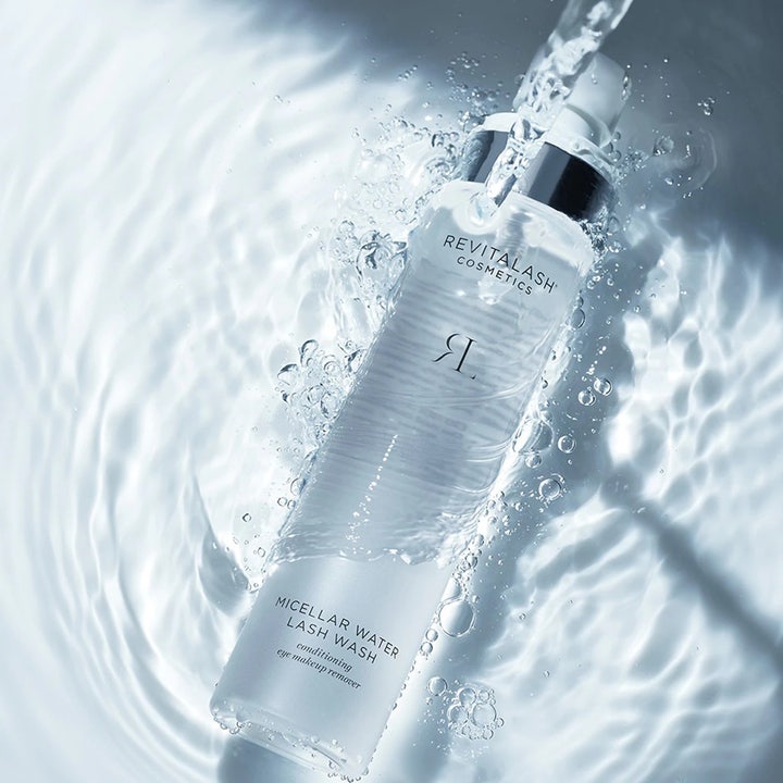 RevitaLash Micellar Water Lash Wash 100 ml plejende ansigtsrens i klar flaske omgivet af friske vandstænk og bobler.