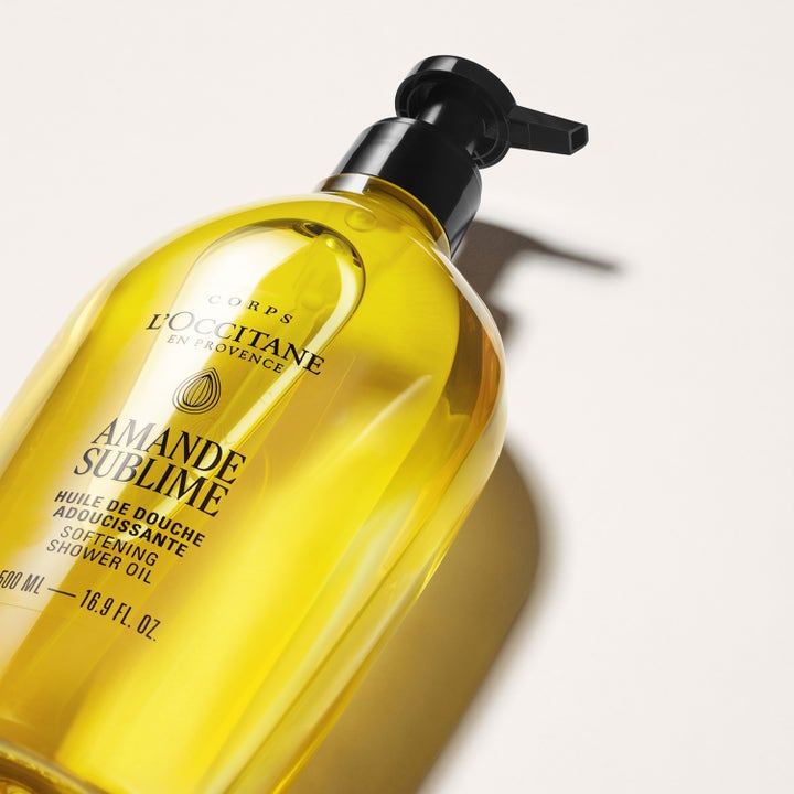 L'Occitane en Provence Almond Shower Oil 500 ml blødgørende badeolie i klar flaske med sort pumpe og gylden tekstur