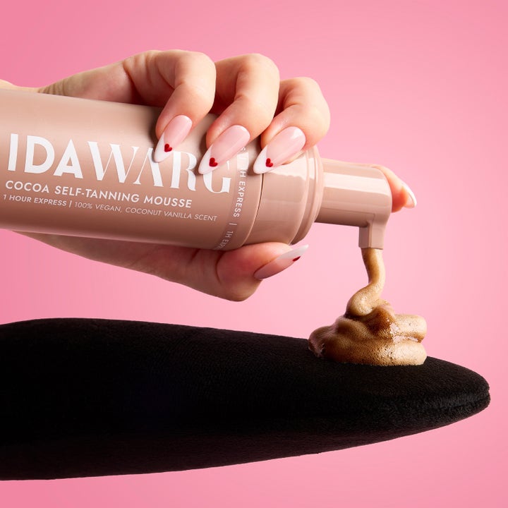 IDA WARG Cocoa Self-Tanning Mousse 150 ml giver glød med brun skumtekstur på en sort påføringshandske