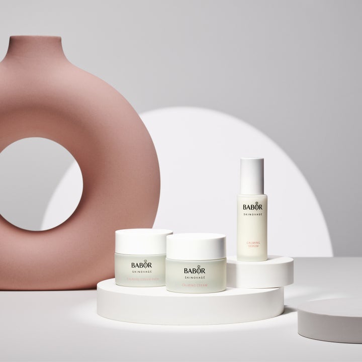 Babor Calming Serum 30 ml beroligende ansigtsserum i hvid flaske på hvide podier med en stor lyserød dekorationsvase.