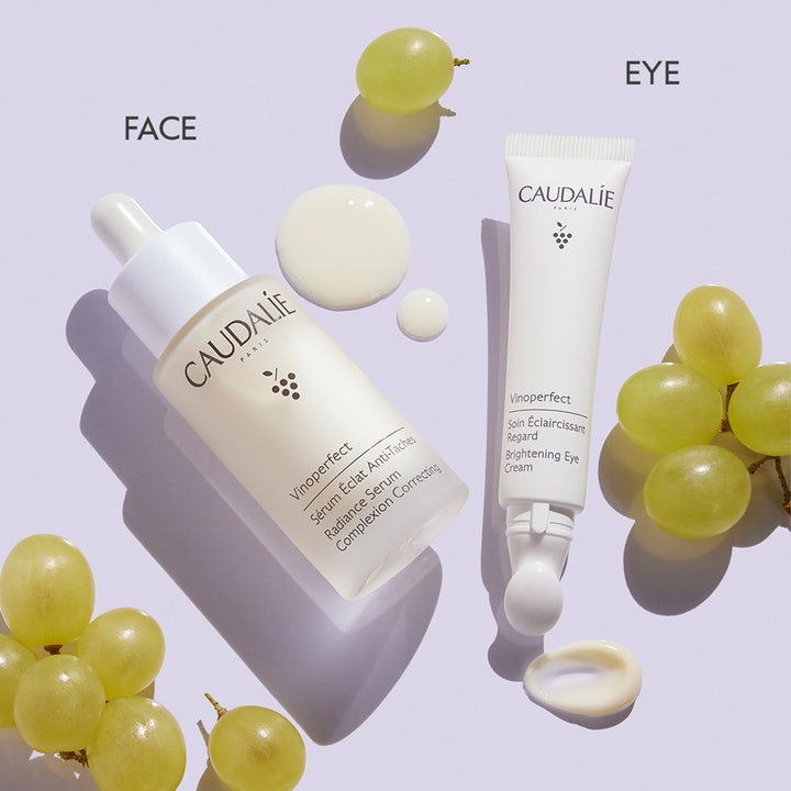 Caudalie Vinoperfect Brightening Eye Cream 15 ml lysnende øjencreme i hvid tube vist med serum og friske grønne druer.