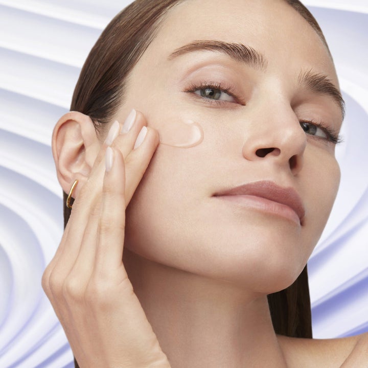 Lancôme Plump & Firm Kit hudplejesæt for øget fasthed viser en kvinde der påfører klar gel på kinden