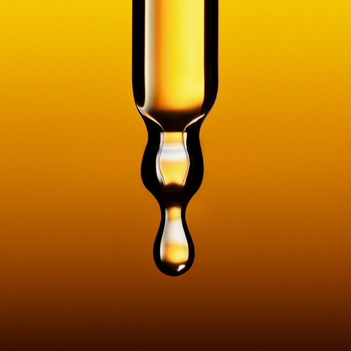 Jorgobé Antioxidant Self-Tan Drops 30 ml giver naturlig glød vist med en gylden serumdråbe fra en pipette.
