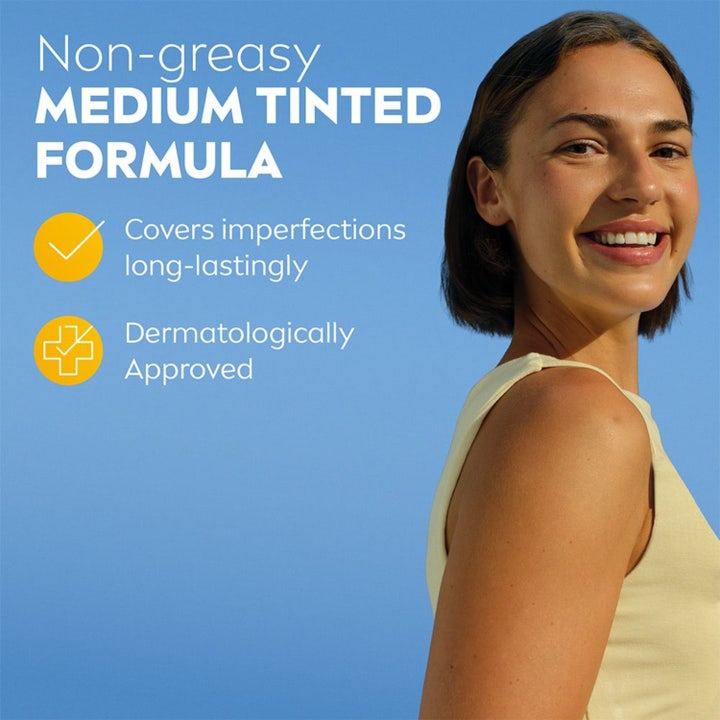NIVEA UV Face Ultra Fluid Medium Tinted SPF50+ 40 ml tonet solcreme giver jævn hud på smilende kvinde mod blå himmel