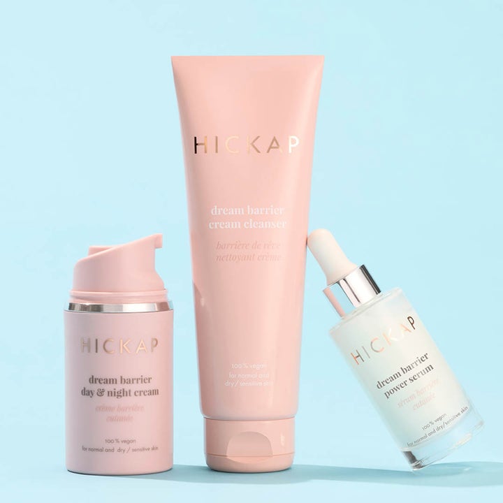Hickap Dream Barrier Cream Cleanser 125 ml fugtgivende ansigtsrens i lyserød tube vist med serum og creme på blå baggrund.