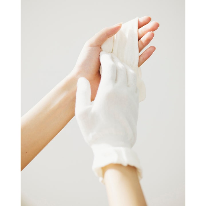 Sensai Cellular Performance Treatment Gloves 1 par handpleje hvide bomuldshandsker vist i brug på hænderne