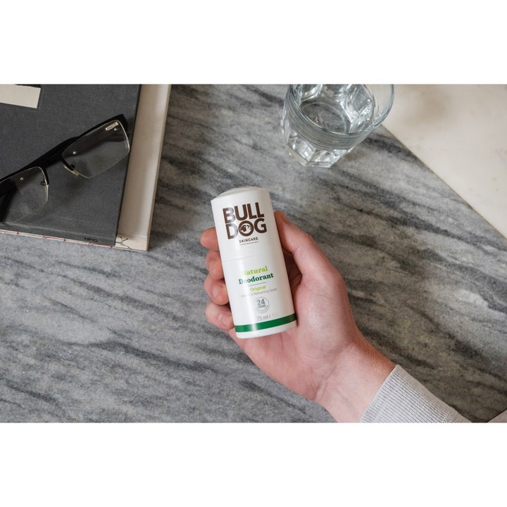 Bulldog Deodorant Original 75 ml i hvid stift holdes af en hånd i et moderne hverdagsmiljø