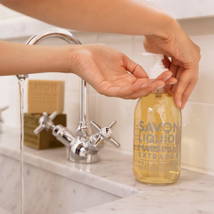 Compagnie de Provence Liquid Marseille Soap 495 ml fugtgivende håndsæbe i glasflaske vist i brug ved vasken