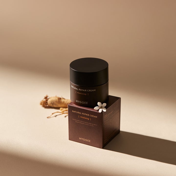 Hyggee Natural Repair Cream 50 ml vitaliserende ansigtscreme i mørkebrun krukke vist med ginsengrod.
