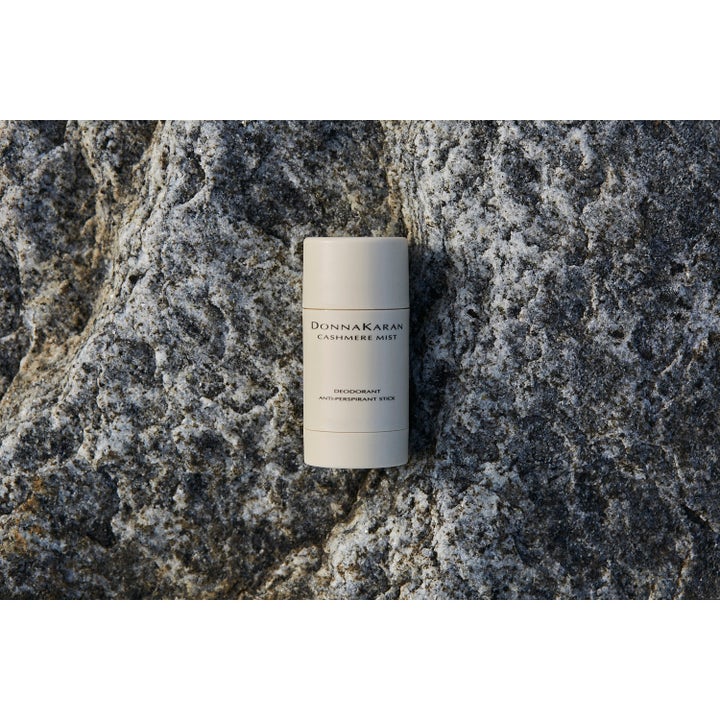 DKNY Cashmere Mist 50 ml deostick mod sved i beige hylster placeret på en rå, grå klippesten