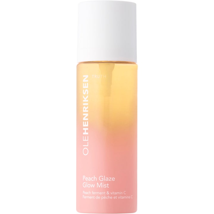 Ole Henriksen Peach Glaze Glow Mist ansigtsspray med C-vitamin i en ferskenfarvet gradientflaske med hvidt låg.