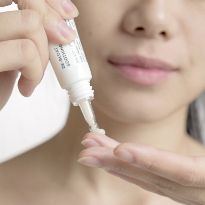 Niche Beauty Lab Transparent Lab De-Bloat Soothing Eye Serum 15 ml dæmper hævelser med let creme på en finger