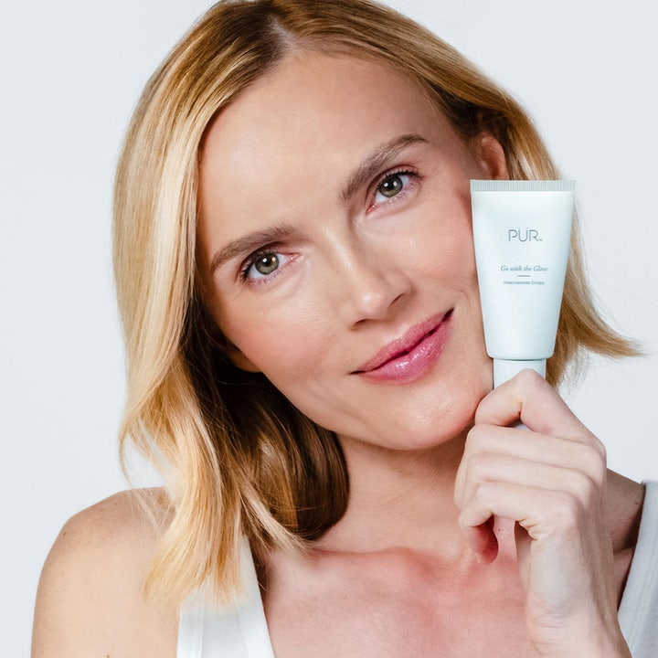 PÜR Go With The Glow Niacinamide Drops 30 ml glødgivende serum vist på en kvinde der holder den hvide tube