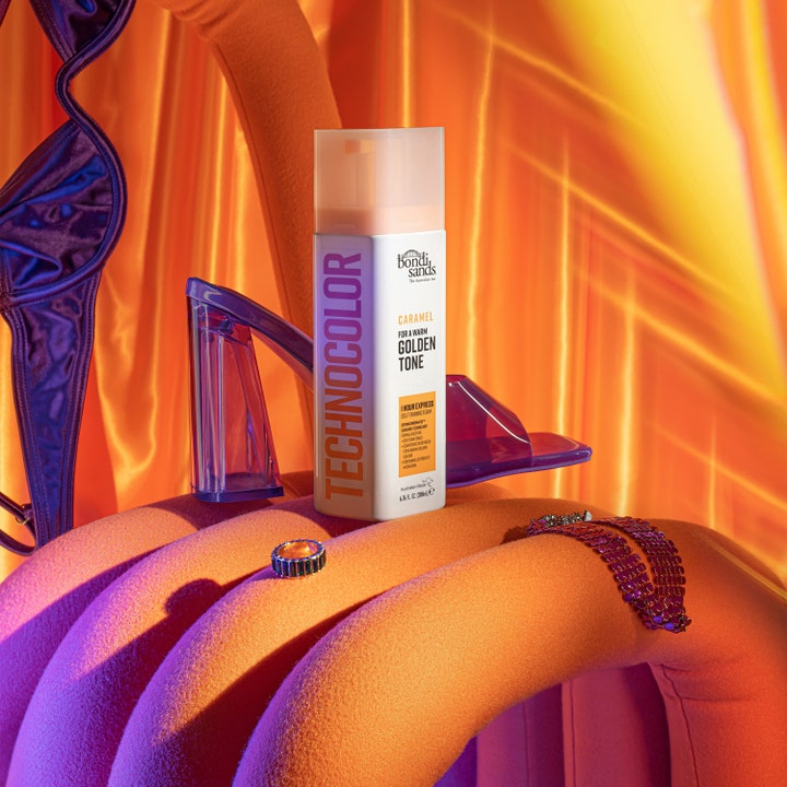 Bondi Sands Technocolor Face Serum Caramel 50 ml selvbruner ansigt ved lilla stiletter for en varm gylden glød.