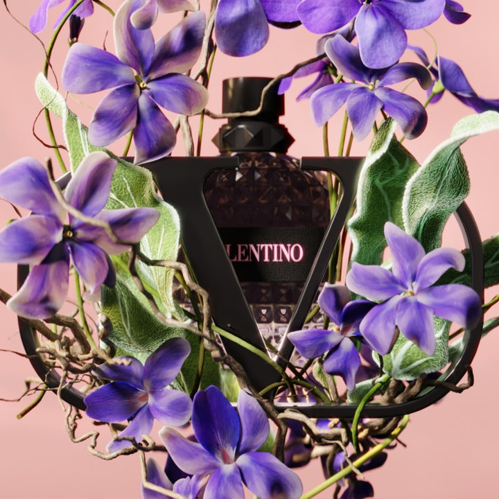 Valentino Born in Roma Uomo Eau de Toilette 100 ml herreparfume omgivet af lilla blomster og et sort V-logo