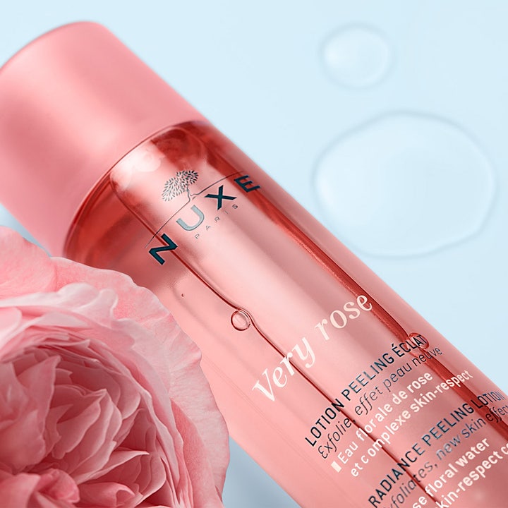 Nuxe Very Rose Peeling Lotion 150 ml eksfolierende ansigtsskrub i lyserød flaske med en frisk rose
