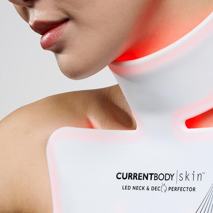 Currentbody Skin Neck and Dec Perfector LED-enhed til hudpleje der lyser med rødt lys på hals og dekolletage