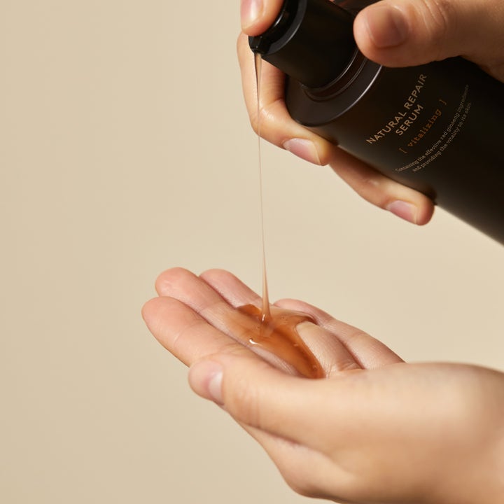 Hyggee Natural Repair Serum 120 ml vitaliserende ansigtsserum med ravgul tekstur der hældes i en hånd