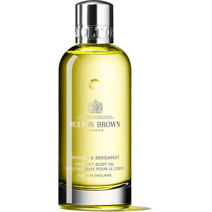 Molton Brown Orange & Bergamot Radiant Body Oil 100 ml giver glÞd i en klar glasflaske med sÞlvlÄg.