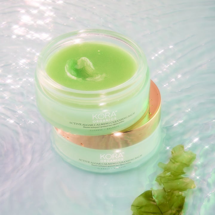 KORA Organics Active Algae Melting Cleansing Balm 100 g beroligende ansigtsrens med grøn balm i krukke i vand.