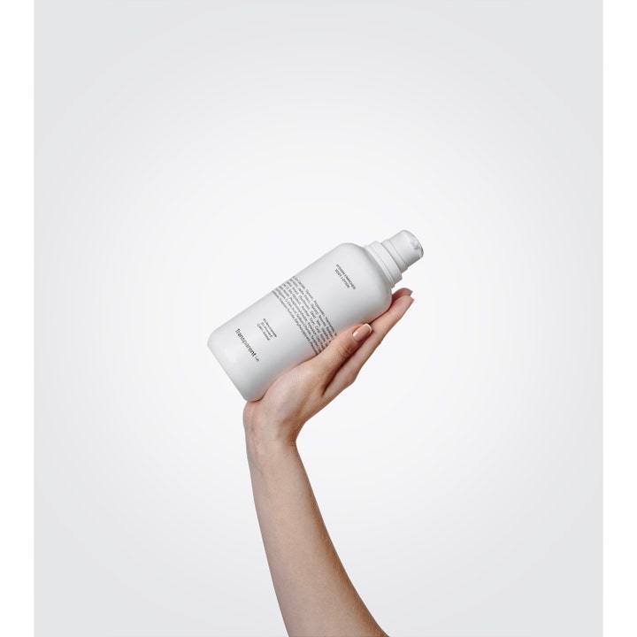Niche Beauty Lab Transparent Lab Vitamin Enriched Body Lotion 400 ml i hvid pumpeflaske holdt af en hånd