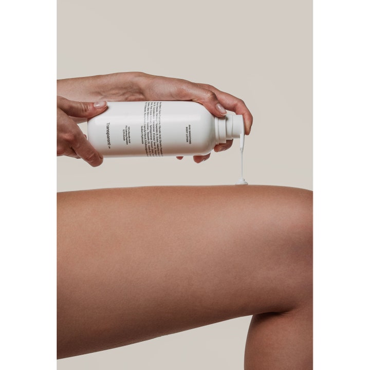 Transparent Lab Aha Smoothing Body Lotion 400 ml eksfolierende creme pumpes fra hvid flaske på et ben for blød hud.