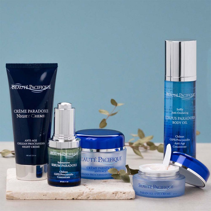 Beauté Pacifique Crème Paradoxe Eye Cream 15 ml i blå krukke med hvid creme og spatel i et luksuriøst miljø