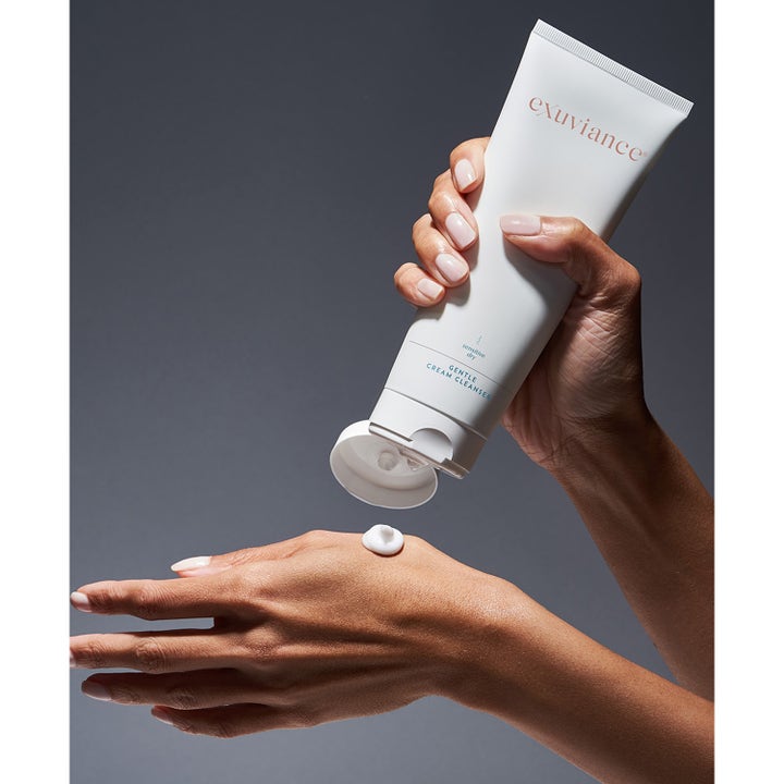 Exuviance Gentle Cream Cleanser 212 ml beroligende ansigtsrens i hvid tube trykkes ud på en hånd