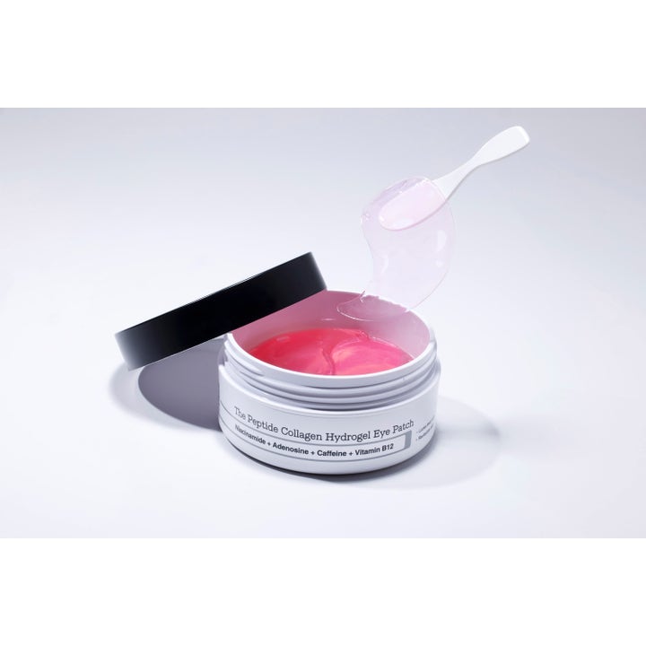 COSRX The Peptide Collagen Hydrogel Eye patch 60 stk giver glød. Lyserød gelmaske løftes med spatel fra den hvide krukke.