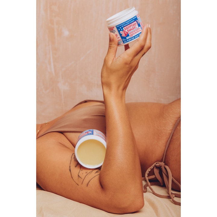 Egyptian Magic All Purpose Skin Cream 118 ml fugtgivende creme i krukke holdt af person i en afslappet atmosfære